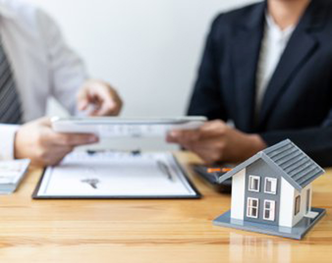 to personer der sidder og kigger på et papir hvor de snakker om rådgivning ved byggeprojekt